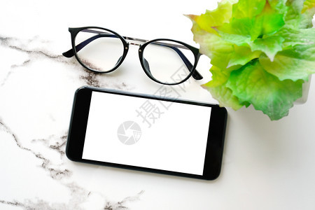搜索白色大理石桌背景上空白屏幕和眼镜的智能电话用于模拟板技术和生活方式概念为模型技术和生活方式概念家移动的图片