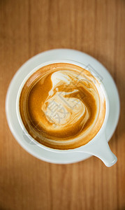 复制店铺Wooden桌边的热咖啡拿铁杯垂直相片最佳视图浓咖啡图片