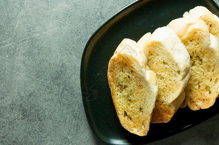 桌上的大蒜和草药面包切片加大蒜的美味面包起司香菜小吃图片