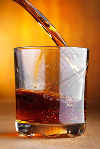 黑暗的一种酒威士忌倒在玻璃杯里图片