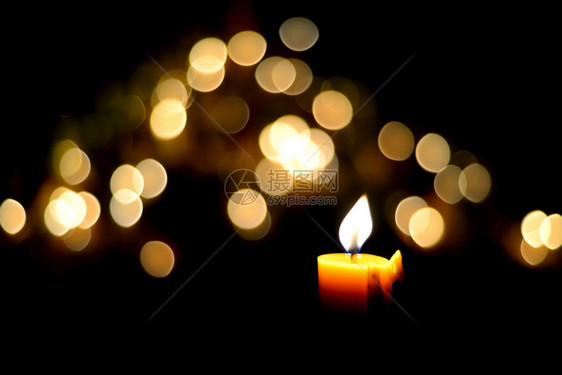 黑暗戳黄色的夜里一朵蜡烛火和bokeh图片