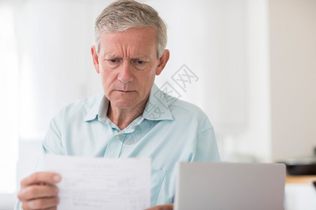 使用笔记本电脑计算家庭财政的焦虑健壮男子不开心退休金融图片