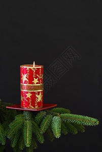 闪发光的黑色葡萄枝上红圣诞节蜡烛黑色背景假期图片