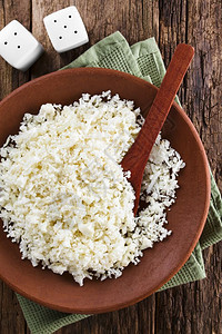 勺子生不含麸质用木勺在盘子上的新鲜花椰菜大米拍摄了RawCauli花稻上方的照片图片