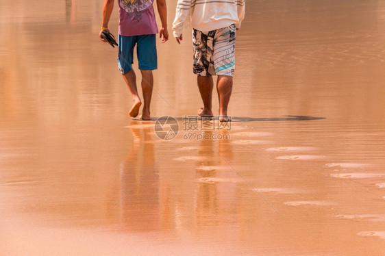 自然2个无法辨认的男子在湿沙上行走下半部的后视角是2人在湿沙上行走两人海洋脚步图片
