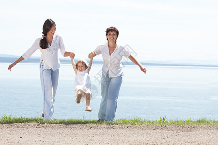 家庭欢乐的微笑母亲和两个Daughtetersr一起在阳光夏日水景台玩随意的快乐图片