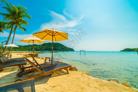 天空蓝色的在美丽热带海滩和洋的伞椅子在天堂岛带椰子棕榈树供旅行和度假之用水图片