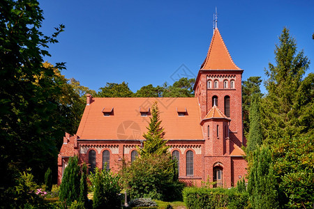 小屋顶市郊森林中的红砖教堂图片