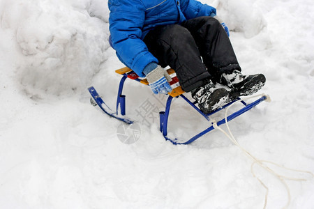在冬天走户外散步时孩子坐在一个雪橇中渡过深时间玩季节图片