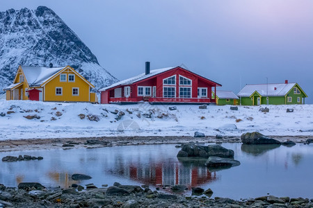 海挪威多色小屋位于冬季晚峡湾边的山顶上冬季傍晚在Fjord和挪威Cottage两地低潮下村庄强盗图片