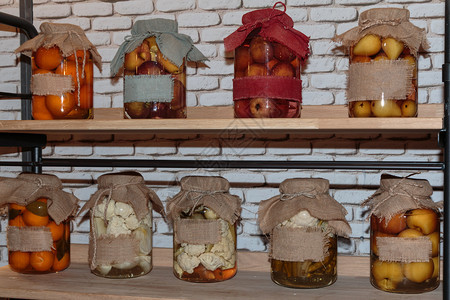 食用碗在木制大陆架玻璃罐内油井中保存的水果和蔬菜腌制图片