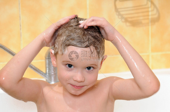 有趣的微笑在淋浴中洗孩子的澡头部有泡沫一种图片