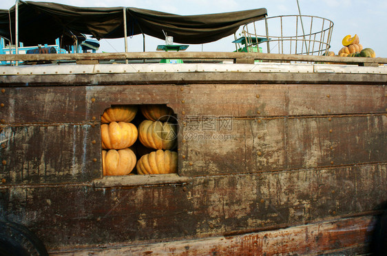 堆叠的漂浮越南湄公河三角洲CaiRang漂浮市场许多黄南瓜的木船运输篮子图片