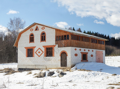 白色的在森林边缘白砖小屋雪覆盖面积春初雪堆阁楼图片