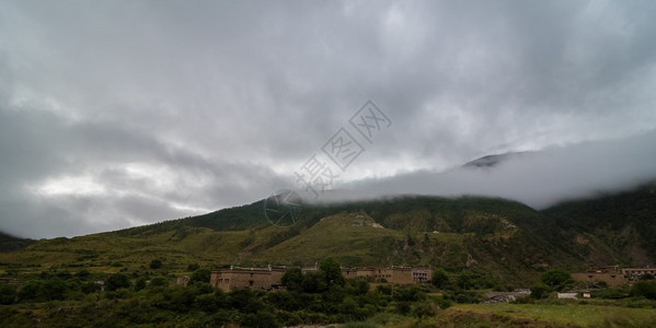 山坡在云中躺着青绿的阴锥被迷雾笼罩在景色风中有雾常绿美丽的图片