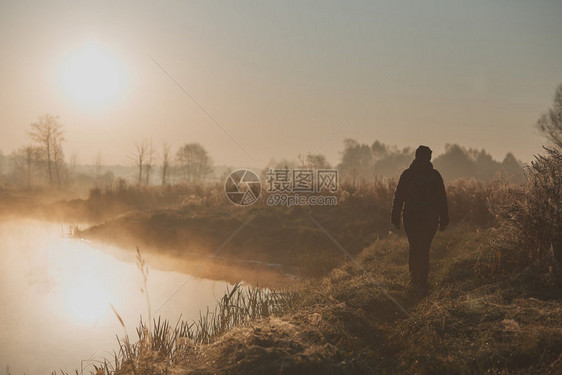 落下女人在雾中清晨太阳的池塘旁走过一个草地在田上升起早水池里充满了雾真实的人情况一种人们图片