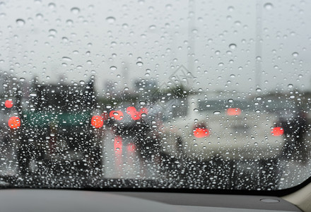挡风玻璃在雨天通过湿风屏看到闪亮驾驶车绿色交通图片