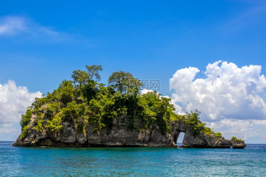 印度尼西亚是一个小岩质热带岛屿其背景是海洋和美丽的风云印度尼西亚洛基热带岛罗比亚胰海岸景观图片