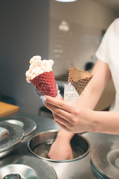 卖家在一糖果店卖几勺冰淇淋由街上的女人给一个甜圈放勺冰淇淋锥体夏天食物图片
