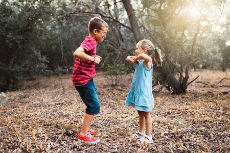 健康两个孩子在森林里玩耍和跳舞运动鞋微笑图片