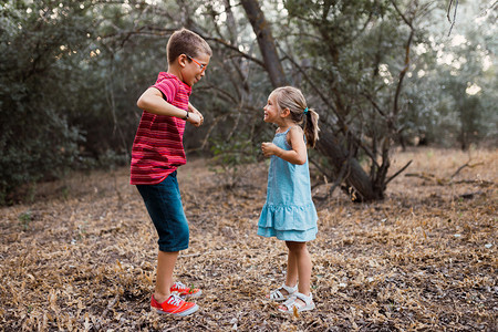 两个孩子在森林里玩耍和跳舞牛仔裤姐快乐的图片