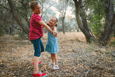 健康两个孩子在森林里玩耍和跳舞运动鞋人们图片