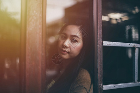 站在窗户旁看的亚洲女人反射沮丧漂亮的图片