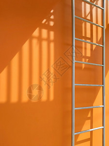 建造爬垂直框中橙色建筑外的消防逃生处表面的紫光和包刀阴影户外图片