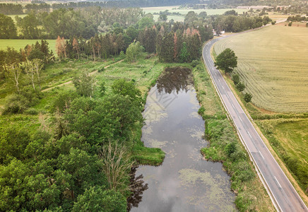 草甸街道在萨克森安哈尔特的一条乡村公路上平行的一个小池塘与周边地区的田和森林相平行的空中观察由无人驾驶飞机制成场地图片