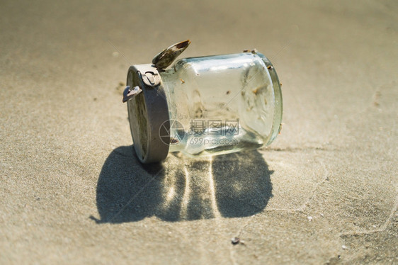 空白的海沙滩上空玻璃瓶图片