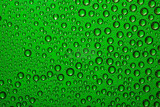 雨浇注充满活力绿玻璃上的水滴图片