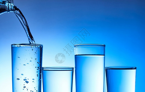 清除将水倒入玻璃中以蓝底为的玻璃杯福利健康图片