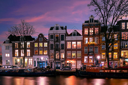 晚上欧洲日落时在荷兰沿着运河的阿姆斯特丹住房地点图片