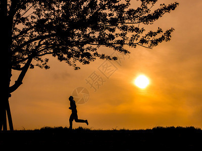 以夜晚日落为背景的亚洲跑步人和樱树之木锻炼桃轮廓图片