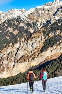 阿尔卑斯山徒步旅行爬女孩朋友在山上雪的冬季漫步中图片