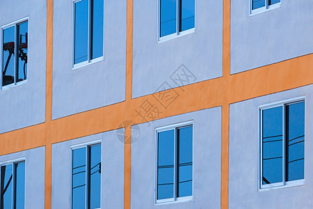 结构体外部的现代建筑墙玻璃窗表面蓝色天空反射的低角度和侧视图现代建筑墙玻璃窗面住宅图片