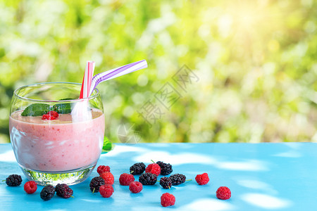 茶点明日下蓝桌的果子绿色天然背景红莓冰淇淋绿色阳光下浆果之桃子绿色天然背景明亮的甜图片