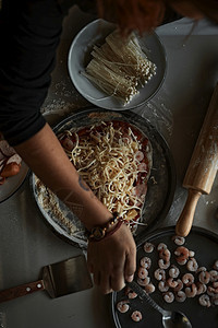 木板美食在撒了面粉的表上制作意大利比萨的手特写制作意大利比萨的手特写可口图片