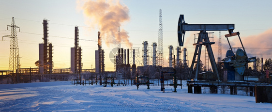 冬天日落空下的石油钻机和甘干茅斯炼油厂气体环境的图片