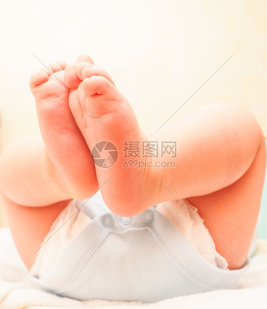 在换尿布和洗澡后有脚在空气中的婴儿男孩生松弛干净的图片