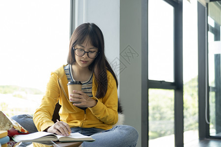 坐在窗边学习的漂亮女孩图片