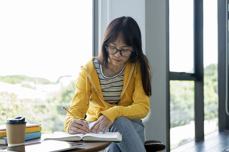 坐在窗边写字的女孩图片