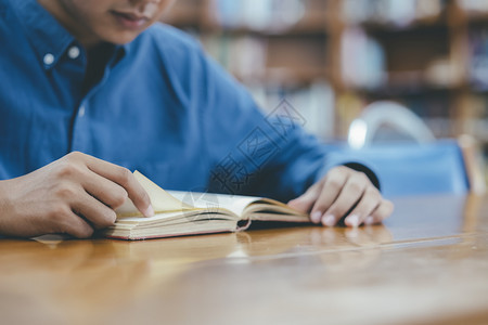 在桌子前阅读的男学生图片