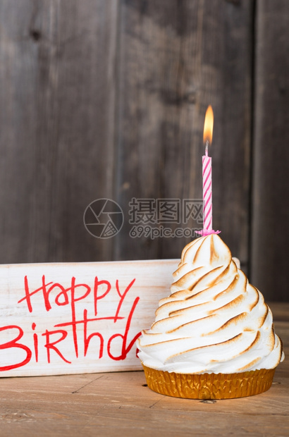 生日快乐旁边有一个蛋糕来庆祝木头家垂直的图片