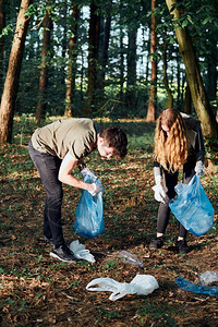 保护孩子采摘清理森林的年轻男女志愿者将塑料垃圾装入袋子塑料污染和过多垃圾的概念环境问题损害对的责任真实人情况图片
