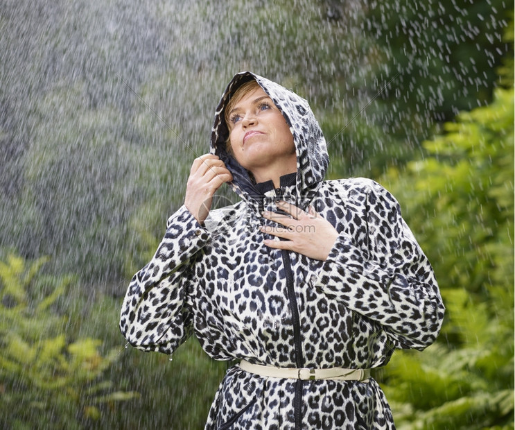 身穿雨衣季夏日背景绿色自然的成熟女下雨天气美丽的图片