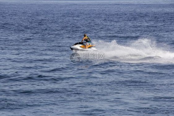 年轻男子在蓝海中乘飞机滑雪臭鼬运动骑术图片