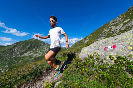 男运动员在山上练习跑步在一条以奥洛比山为标志的足迹上年轻健康身体图片
