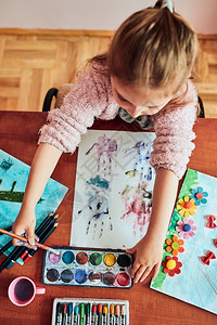 可爱的学龄前小女孩用彩色涂料和蜡笔绘画照片在课堂艺术上做图片时玩得开心的童年儿班级制造图片
