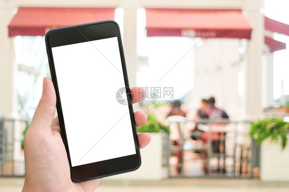 手持智能电话在模糊的餐馆背景模拟板餐厅预订在线食物品供应概念上握有智能电话技术应用程序信息图片